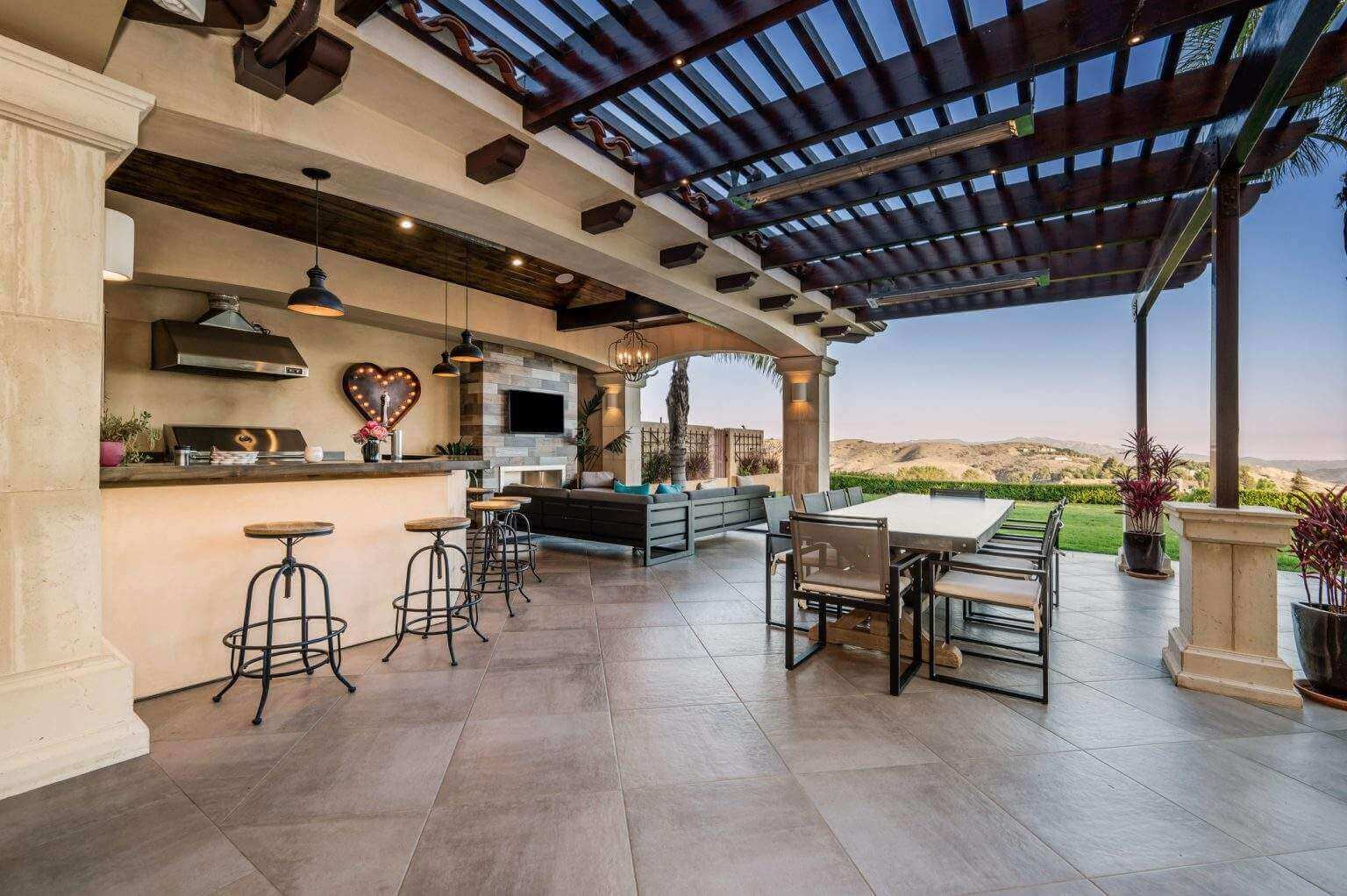outdoor patio with pergola and bar and kitchen